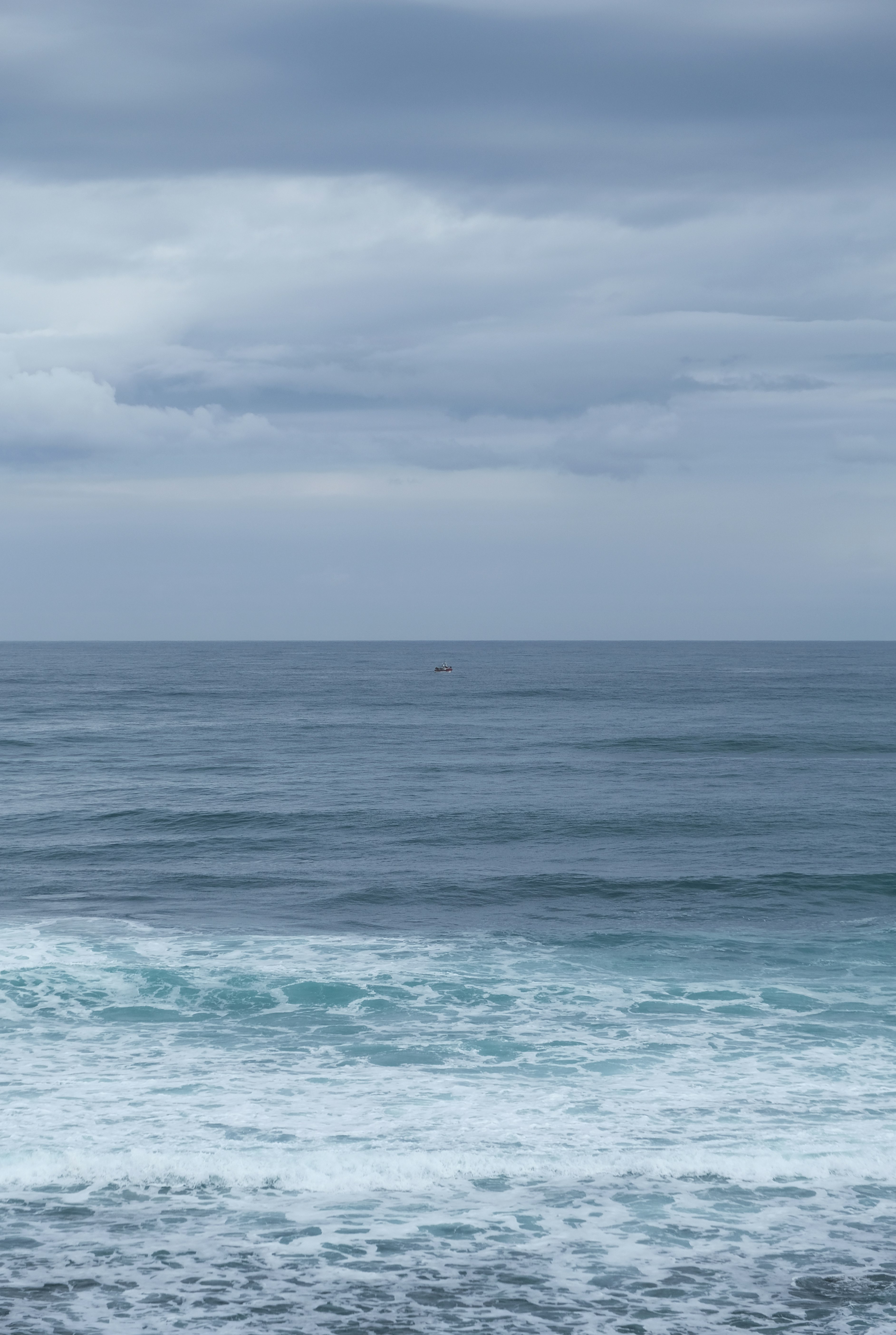 blue ocean water under white clouds during daytime